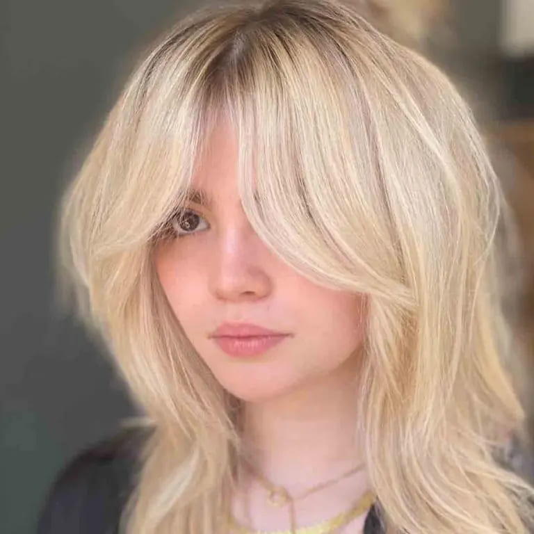 10 Best Wolf Cuts With Curtain Bangs 8 Bleached Blonde Fluffy Wolf Cut With Curtain Bangs