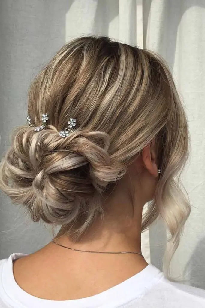10 Elegant Long Hair Updos 11 Floral Accented Low Bun