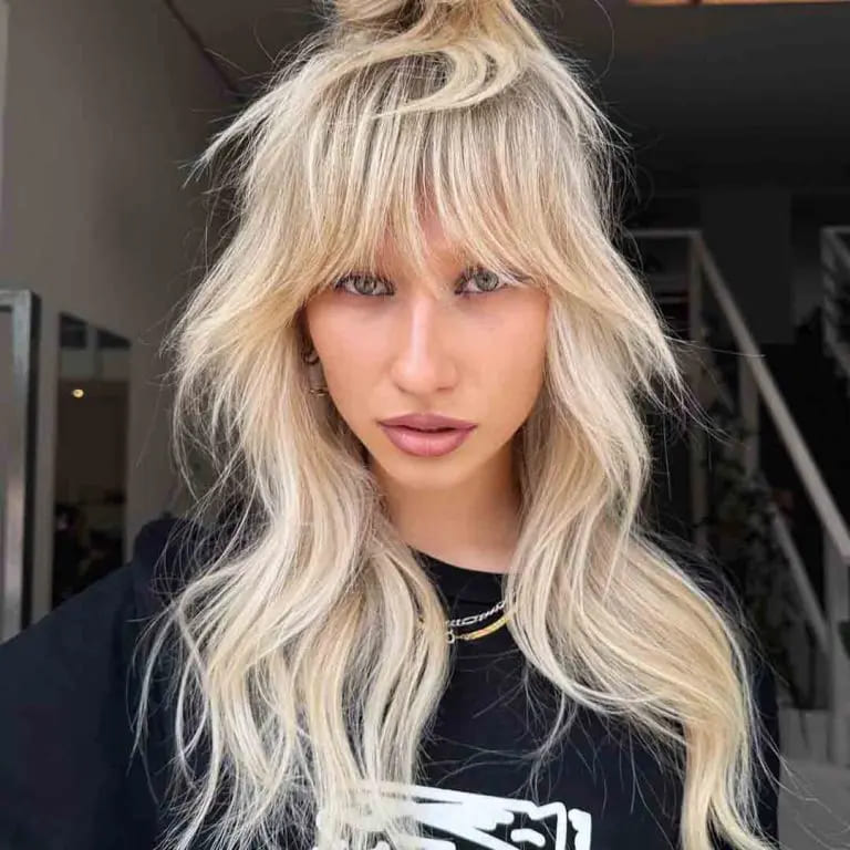 10 Classy Shaggy Wolf Cuts With Bangs 6 Long Shag Wolf Cut with Top Knot and Extended Bangs on Blonde Hair