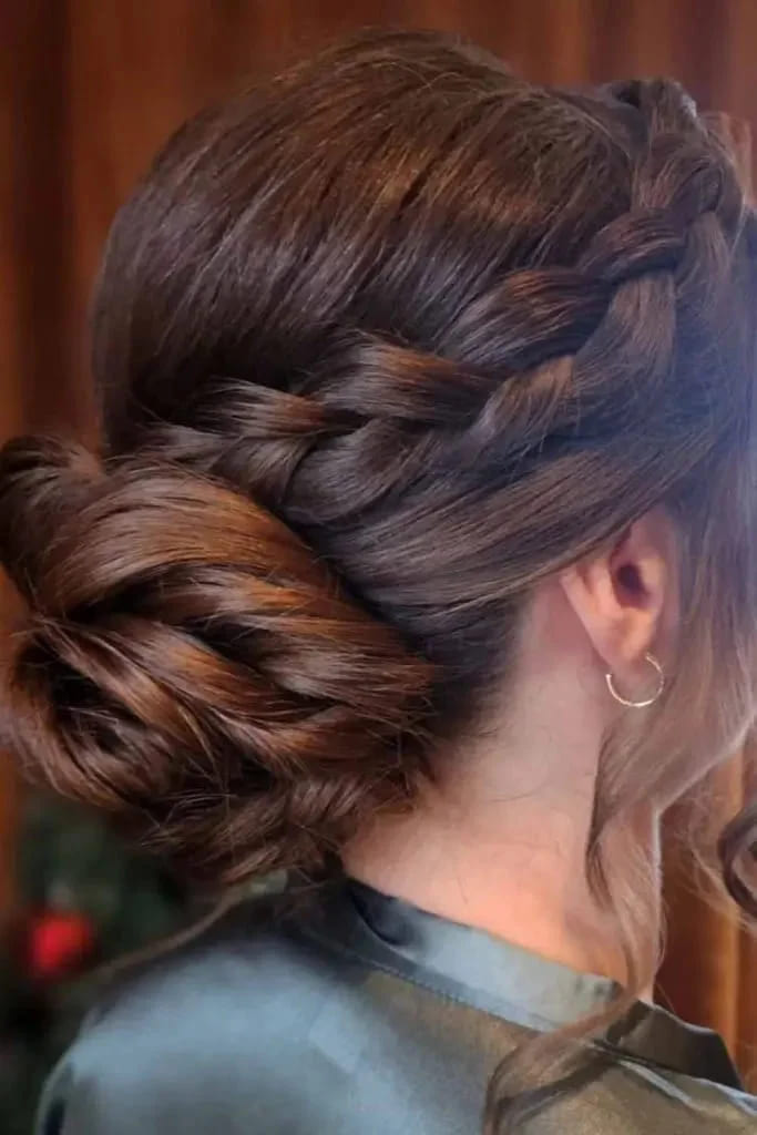 12 Stunning Hairstyles for Bridesmaids 6 Low Plaited Brunette Bun With Wavy Tendrils