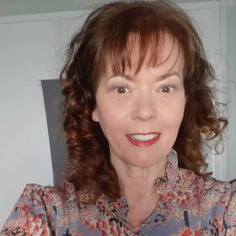 10 Stylish Haircuts for Women Over 50 2 Medium Brown Curly Hair With Wispy Bangs