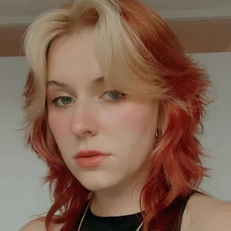 10 Wolf Cuts With Colored Bangs for Added Style 9 Short Ginger Wolf Cut With Blonde Curtain Bangs