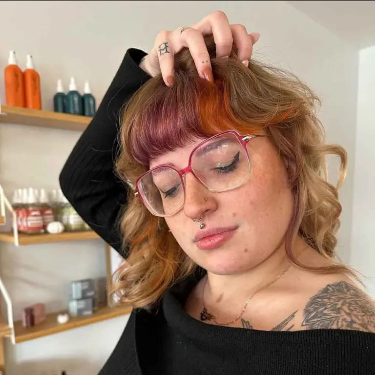 10 Wolf Cuts With Colored Bangs for Added Style 6 Short Wavy Dark Blonde Wolf Cut With Fall-Colored Blunt Bangs