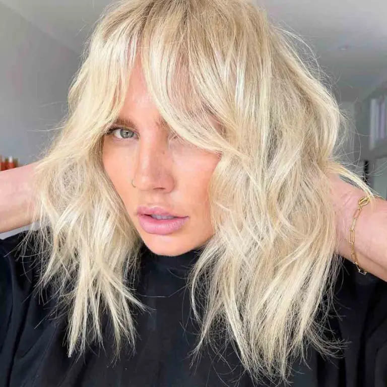 10 Best Wolf Cuts With Curtain Bangs 11 Tousled Blonde Wolf Cut With Curtain Bangs