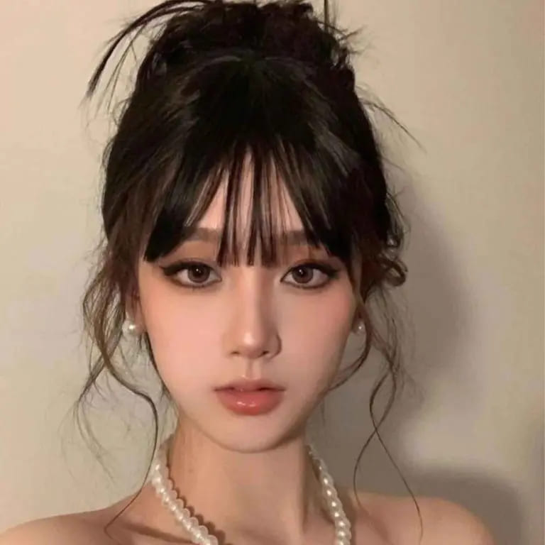 12 Stunning Korean Hairstyles for Women 11 Korean Messy Bun Updo With Bangs