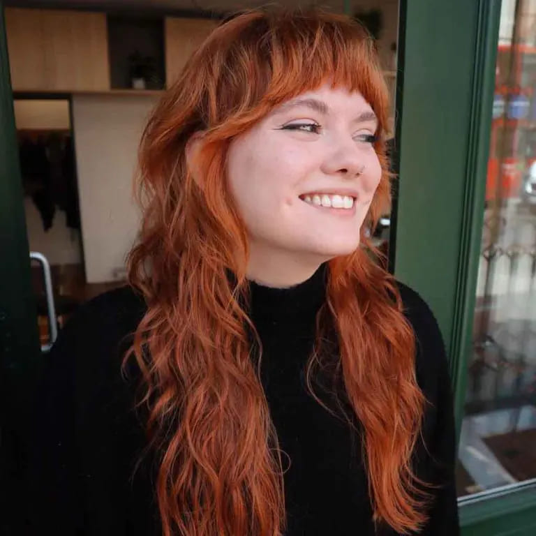 10 Edgy and Stylish Soft Mullet Hairstyles 6 Wavy Shaggy Ginger Soft Mullet With Bangs