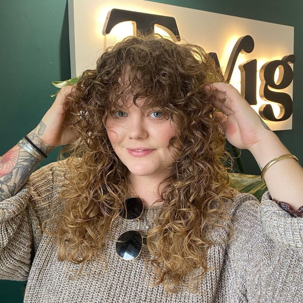 30 Best Curly Wolf Cut Ideas to Showcase Your Beautiful Curls 20 Blonde Curly Long Wolf Cut with Soft Curly Bangs