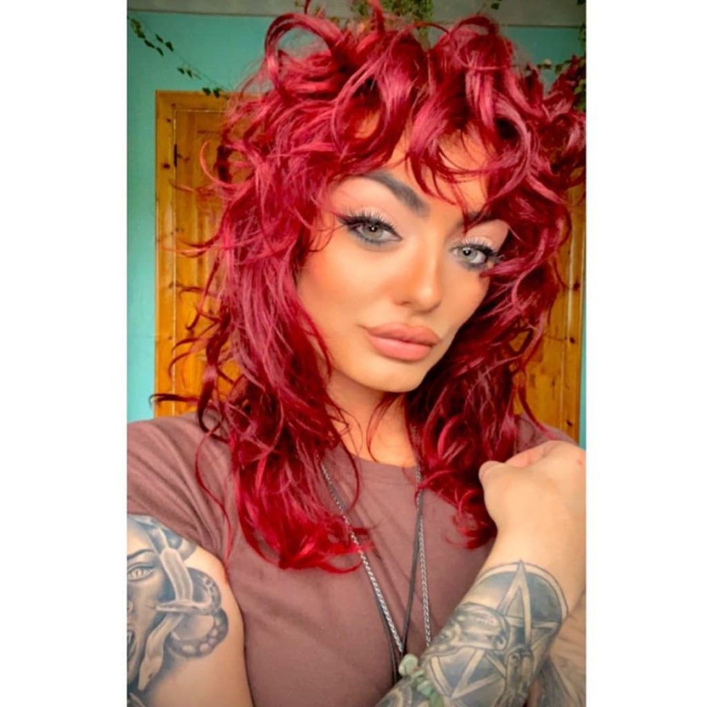 30 Best Curly Wolf Cut Ideas to Showcase Your Beautiful Curls 29 Long Mullet Wolf Cut on Red Colored Curly Hair
