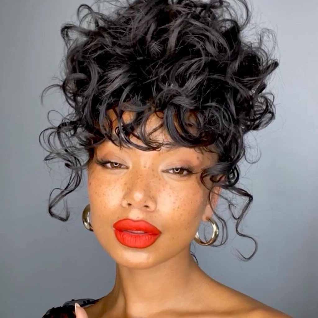 15 Stunning Bun Hairstyles for Elegance! 3 Medium Curly Messy Bun With Curly Bangs