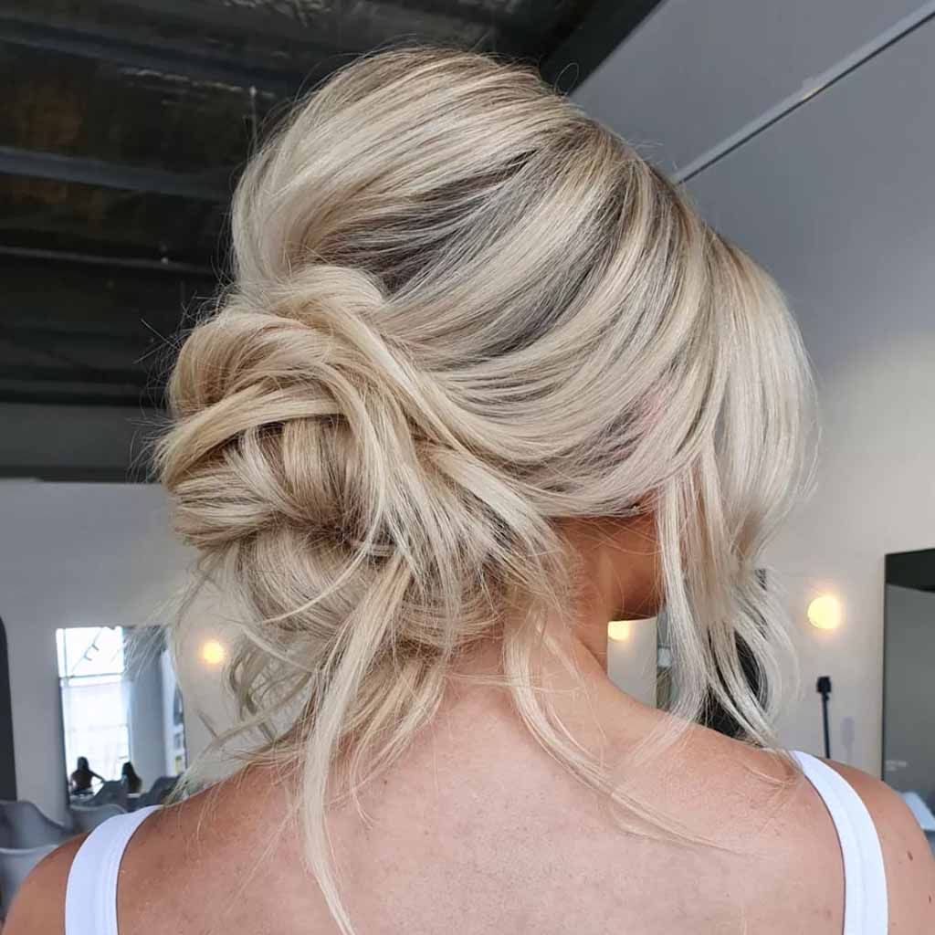 15 Stunning Bun Hairstyles for Elegance! 5 Wavy Messy Blonde Bouffant Bun With Tendrils