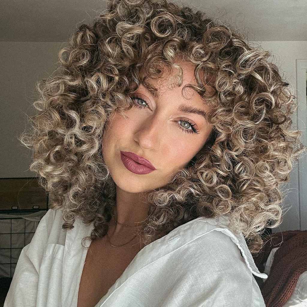 20 Playful Curly Hair Ideas! 6 Bronde Medium Classic Curls With Bangs