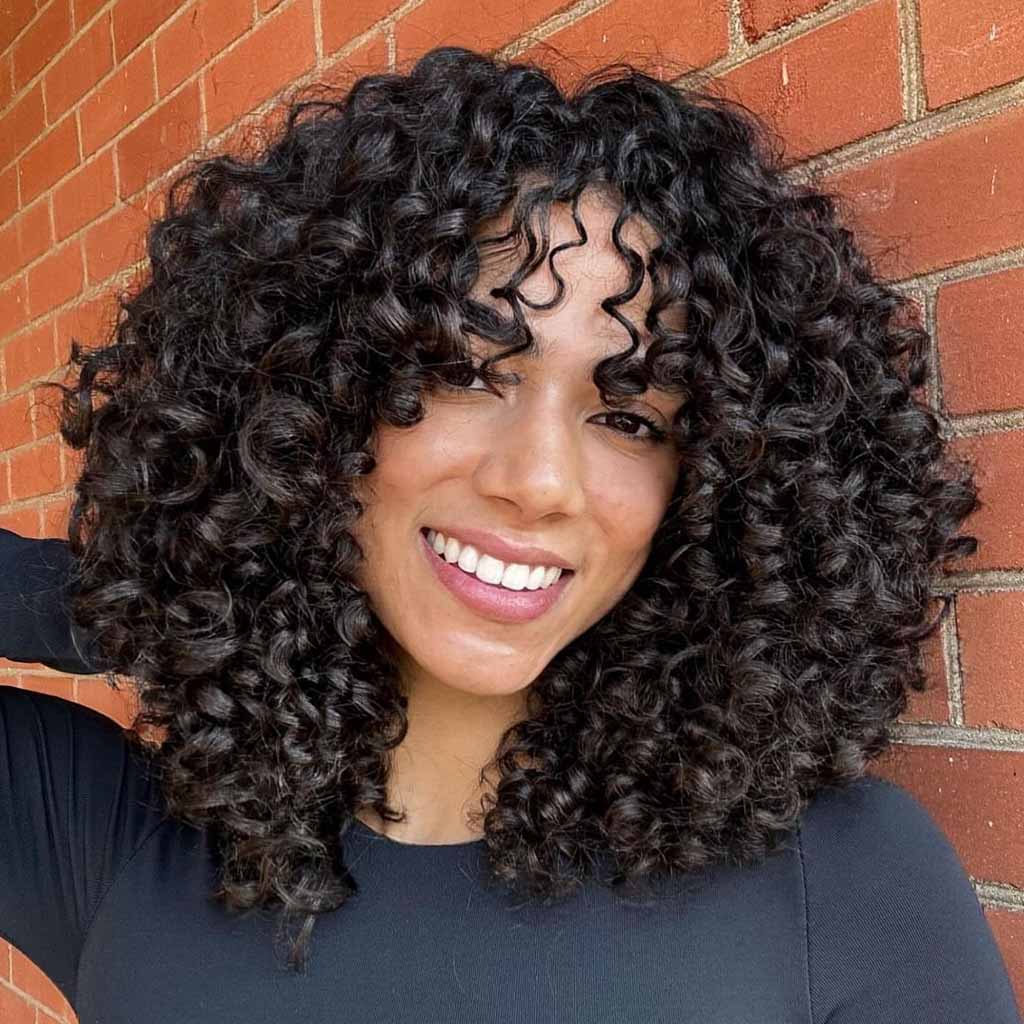 20 Playful Curly Hair Ideas! 11 Medium Black Spiral Curls With Bangs